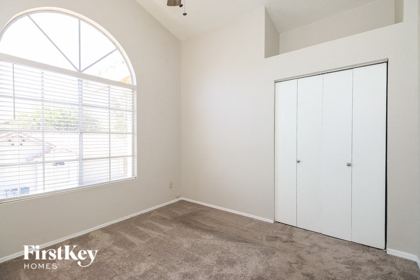 a bedroom with a large window and a closet