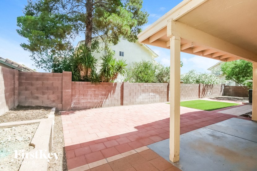 a backyard with a brick retaining wall and a patio