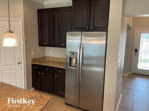 a kitchen with a stainless steel refrigerator and cabinets