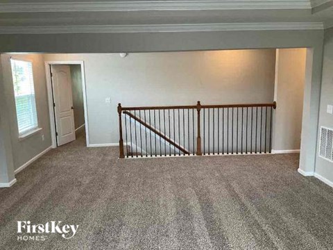 an empty living room with a railing in a house