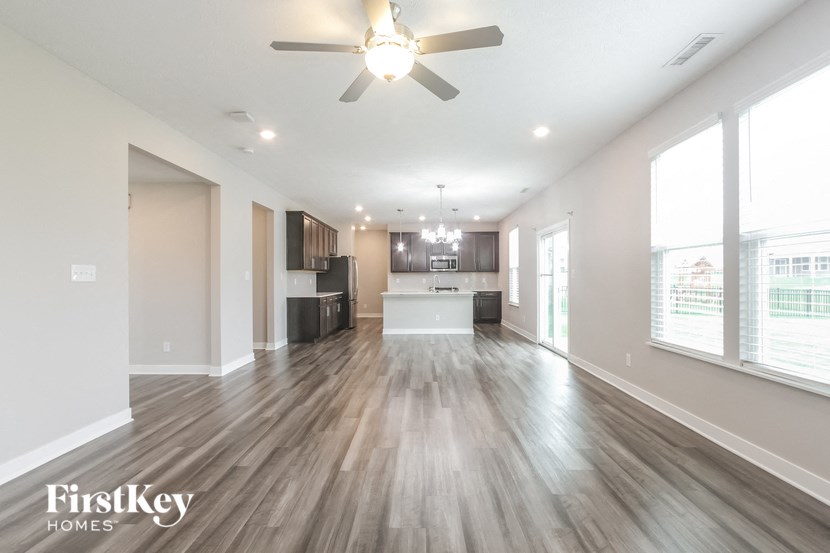 A spacious room with wooden floors and a ceiling fan.