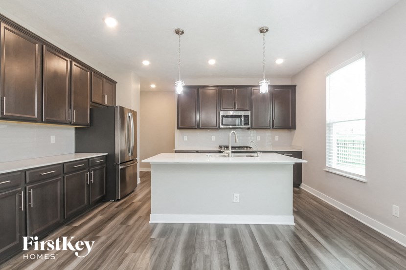 A kitchen with dark brown cabinets and a white island.
