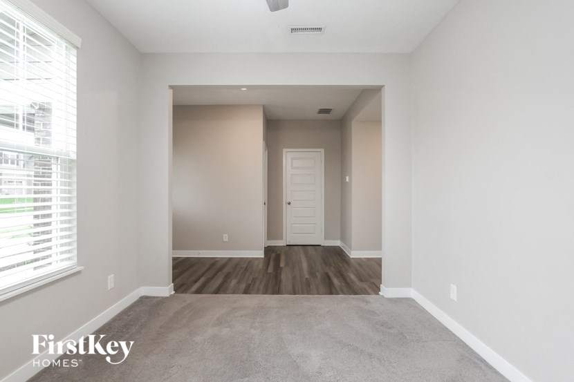 A spacious room with a door at the end of the hallway.