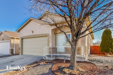 a beige house with a tree in front of it