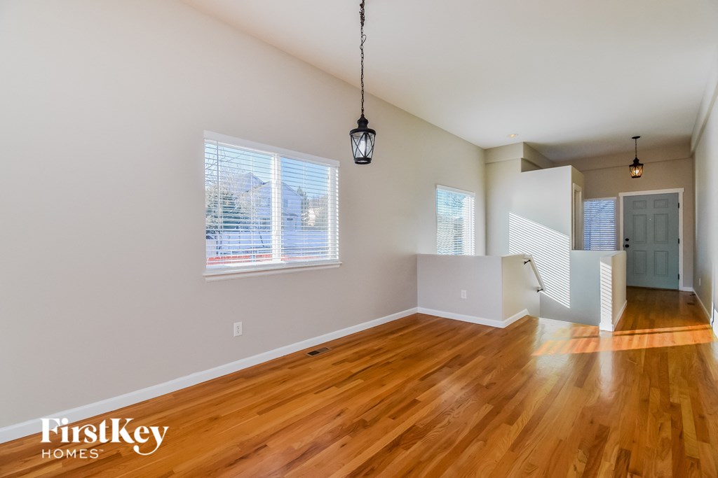 the living room and dining room of an empty house with wood floors