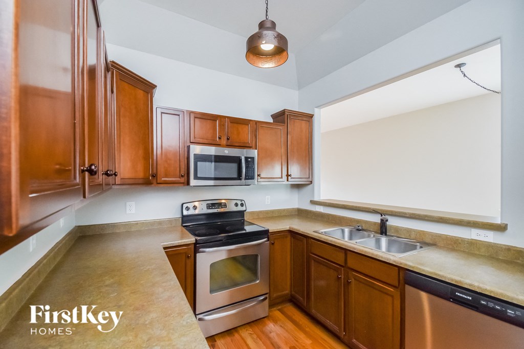 a kitchen with wooden cabinets and stainless steel appliances