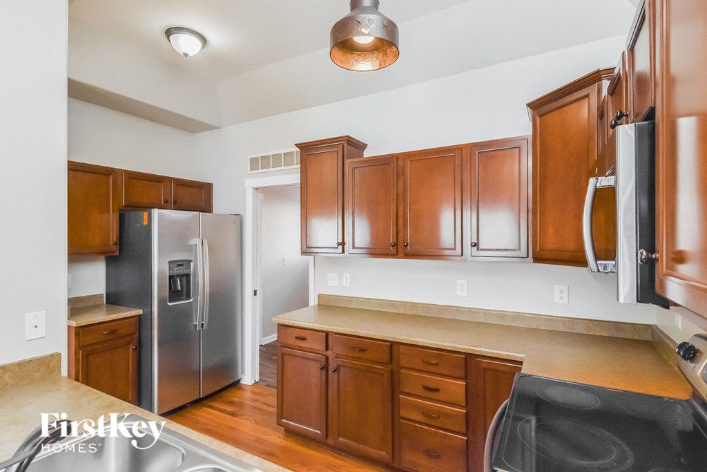a kitchen with wooden cabinets and a stainless steel refrigerator