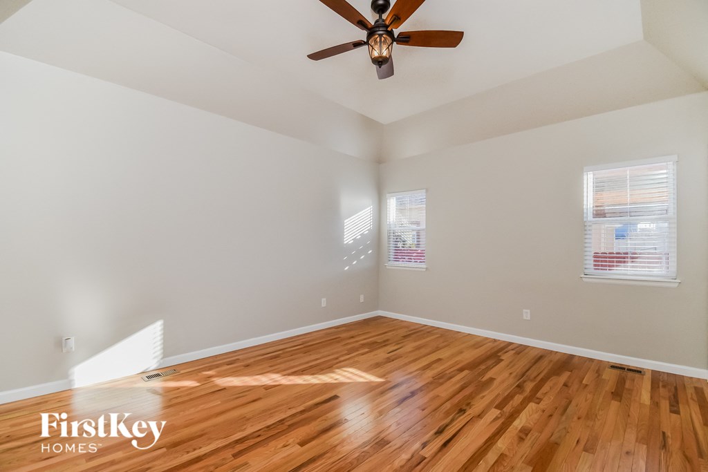 the living room with hardwood floors and a ceiling fan