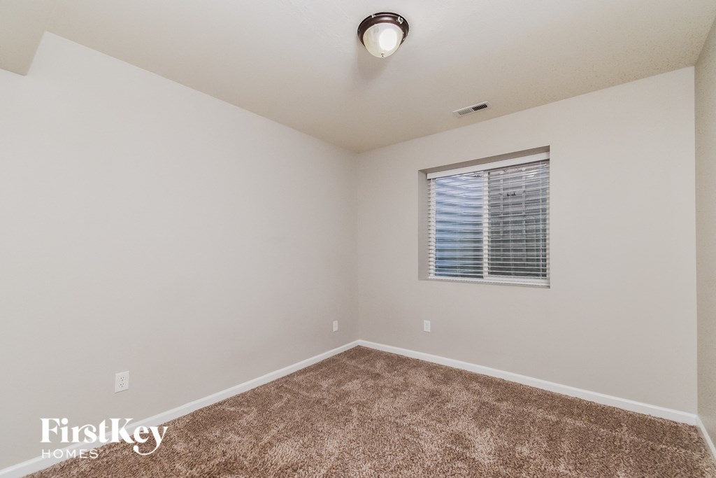 the spacious living room with carpeting and a window