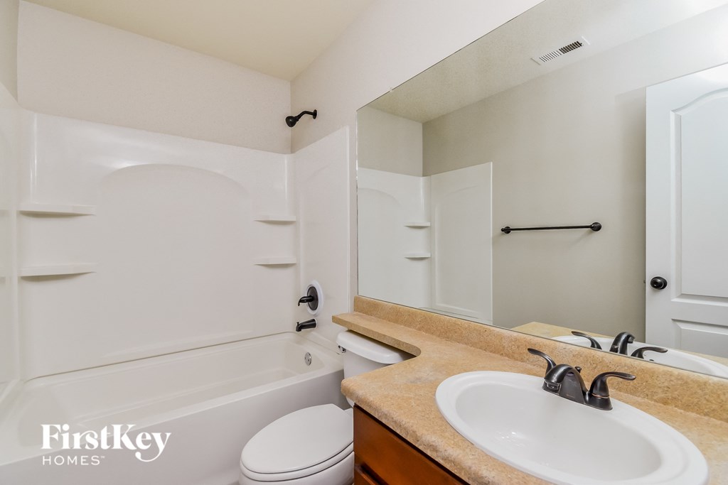 a bathroom with a sink and a toilet and a bath tub