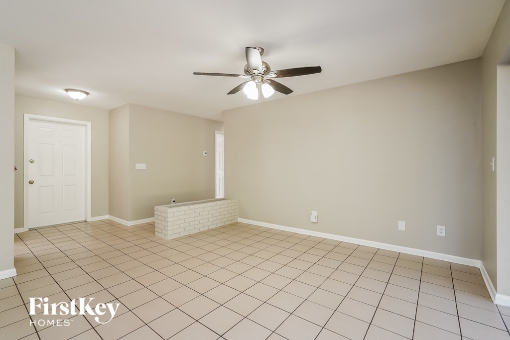 A spacious room with a ceiling fan and tiled floor.