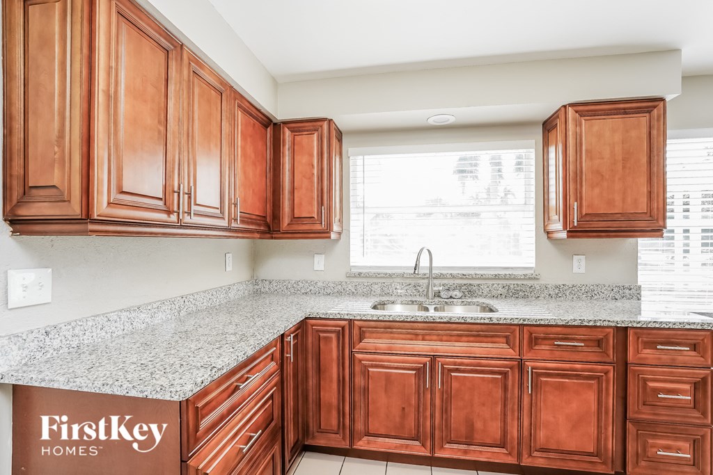 A kitchen with wooden cabinets and a granite countertop.