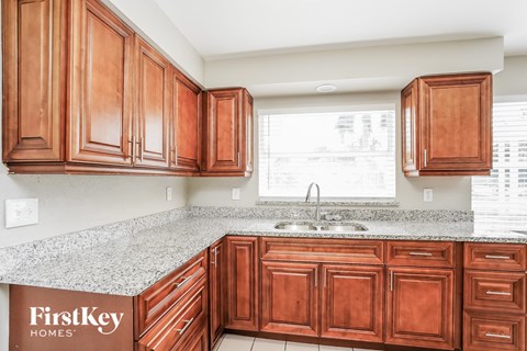 A kitchen with wooden cabinets and a granite countertop.