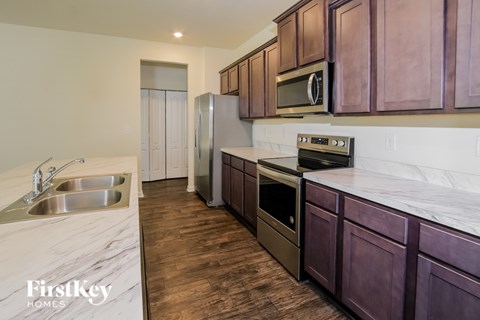 A kitchen with wooden cabinets and a stainless steel refrigerator.