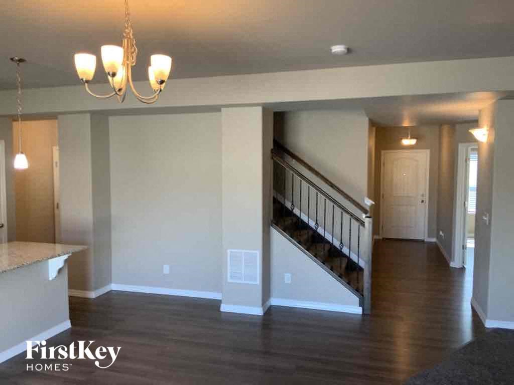 A spacious living room with a staircase leading to the upper floor.