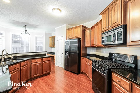 A kitchen with wooden cabinets and black appliances.