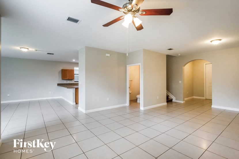 a empty living room with a ceiling fan