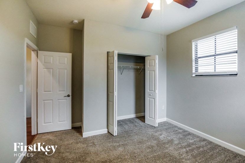 an empty bedroom with a closet and a window