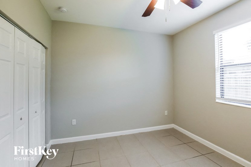 a empty room with a window and a ceiling fan