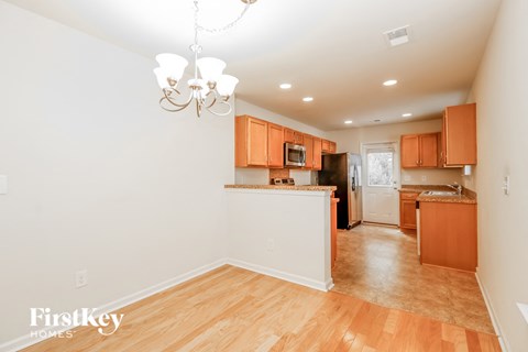 A kitchen with wooden floors and orange cabinets.