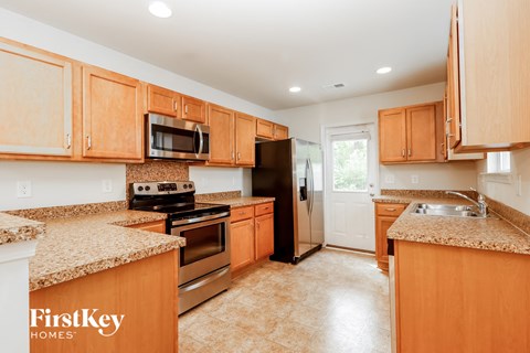 A kitchen with wooden cabinets and granite countertops.