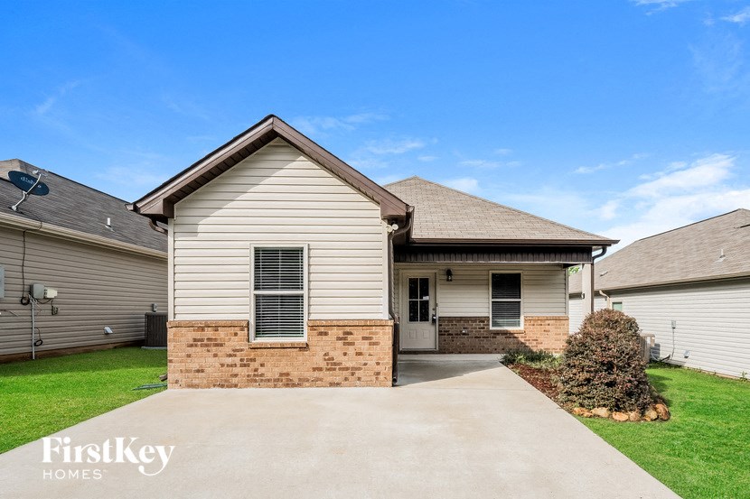 A house with a brown roof and a brick wall is shown.