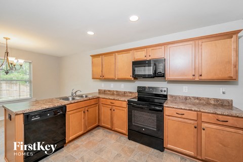 A kitchen with wooden cabinets and black appliances.