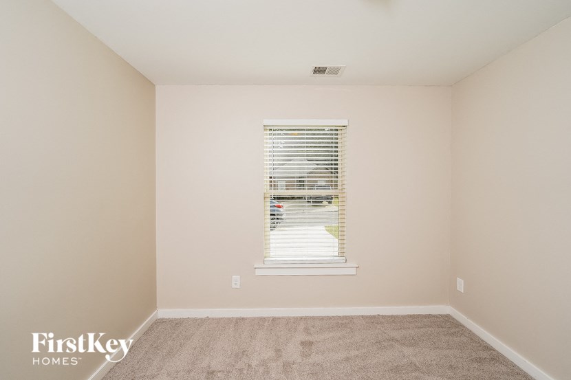 A room with a window and carpeted floor.