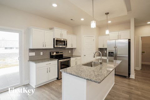 a kitchen with white cabinets and granite counter tops