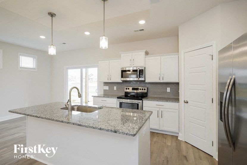 a kitchen with white cabinets and a granite counter top