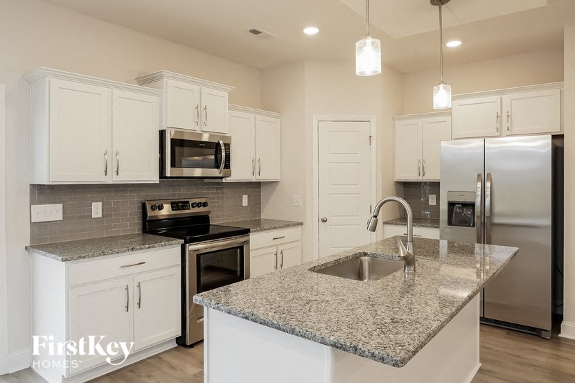 a kitchen with white cabinets and granite counter tops