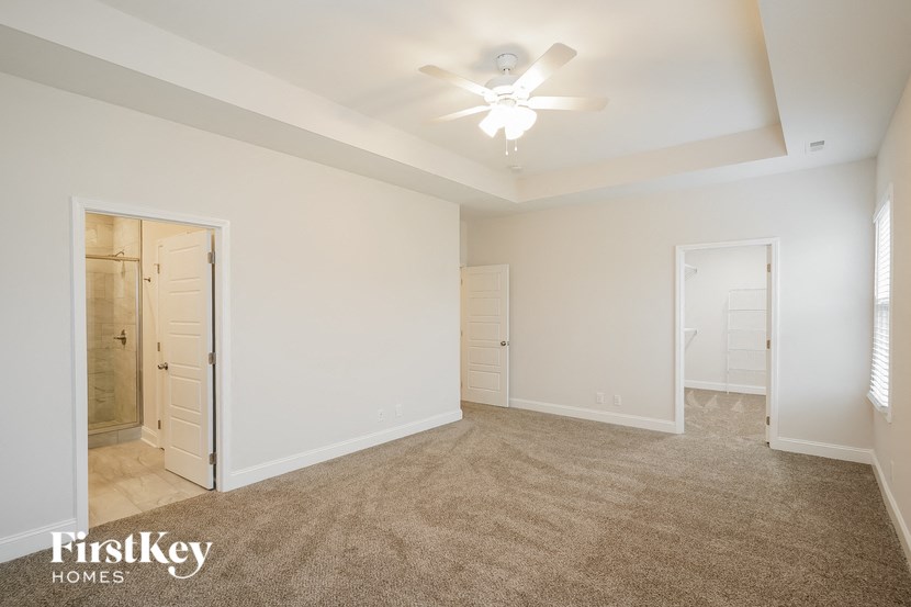 an empty living room with a ceiling fan and a closet