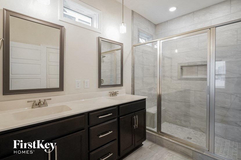a bathroom with two sinks and a shower