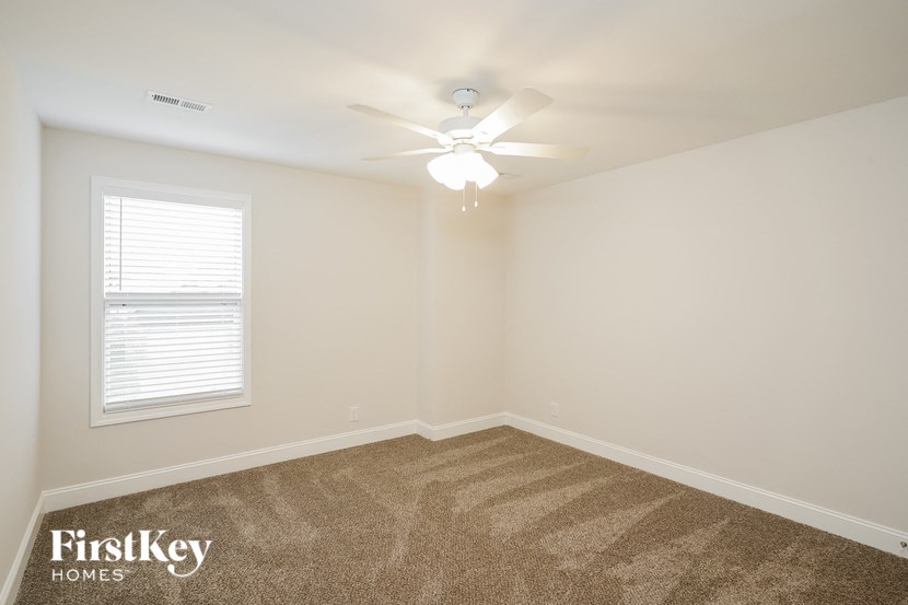 a bedroom with a ceiling fan and a window