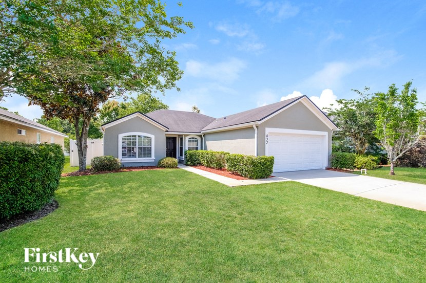 a white house with a lawn and a driveway