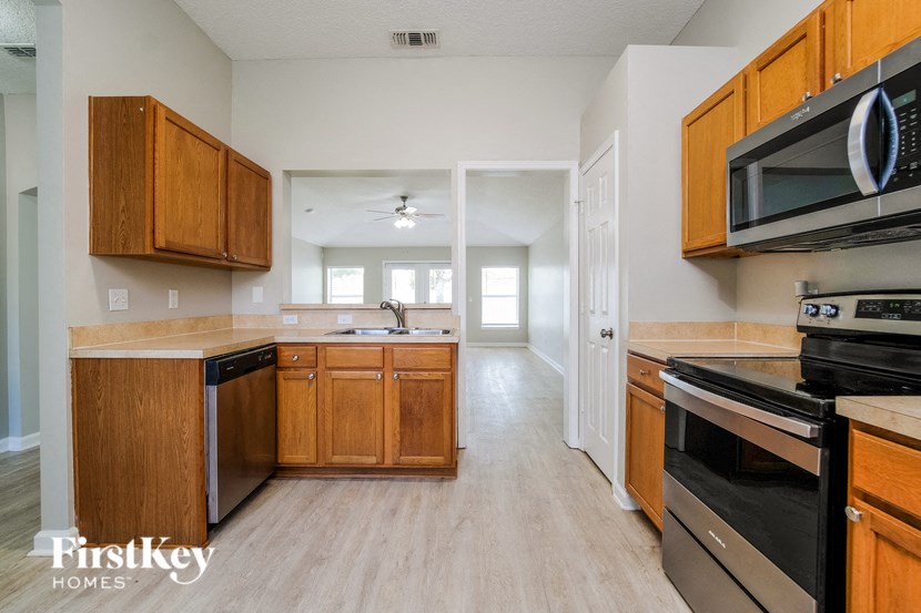 a kitchen with wooden cabinets and black appliances