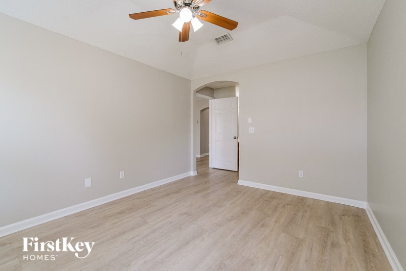 the living room of an empty house with a ceiling fan