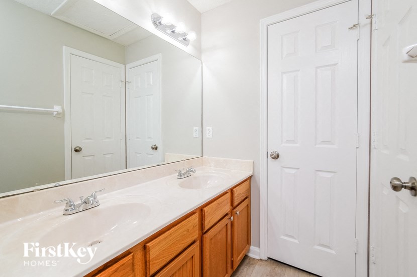 a bathroom with a sink and a mirror and a closet