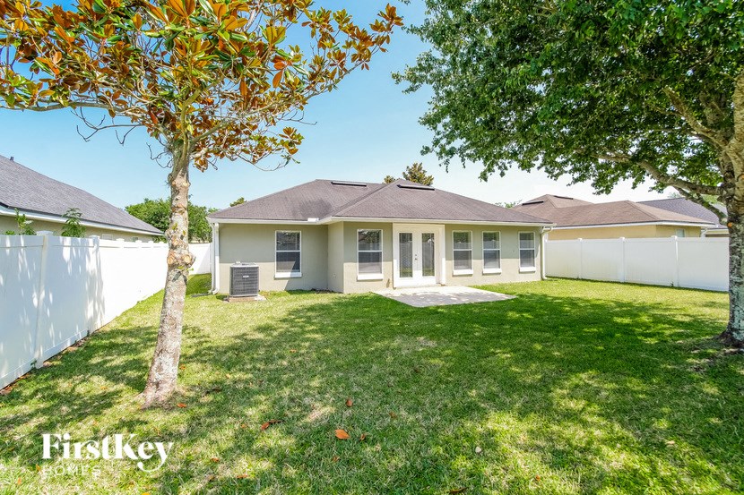 a white house with a yard and a tree