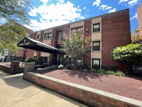 the front of a brick building with a black awning