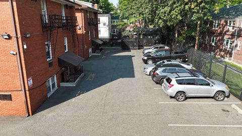 A parking lot with cars parked in front of a brick building.