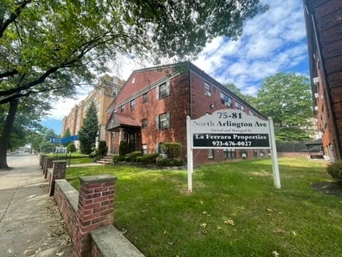 a building with a sign in front of it on the grass