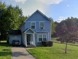 A small blue house with a white door and windows.