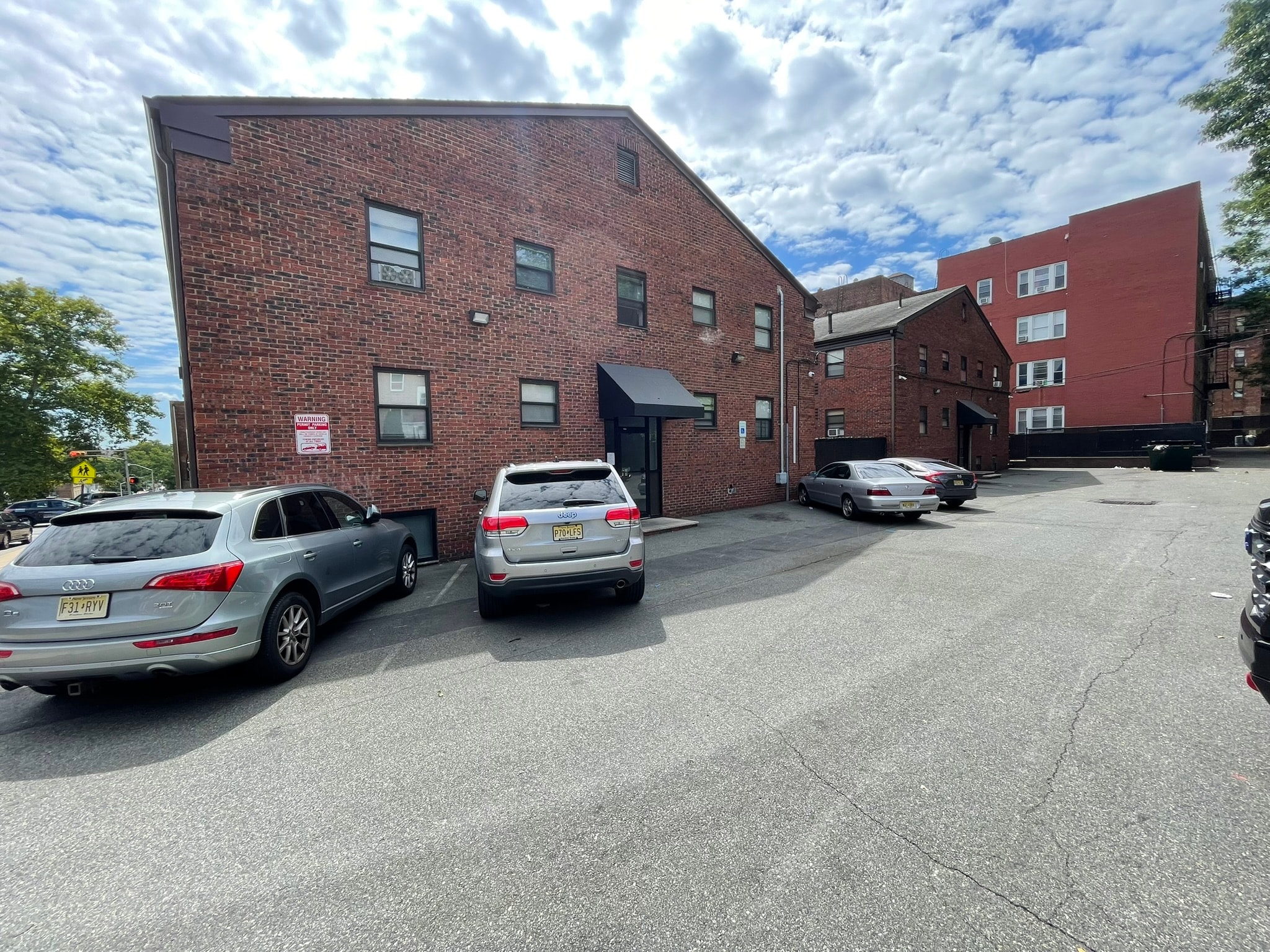 A parking lot with cars and a brick building.