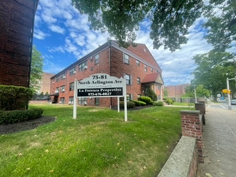 A sign for North Arlington Ave stands in front of a brick building.