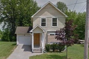 A house with a brown door and a grey roof.