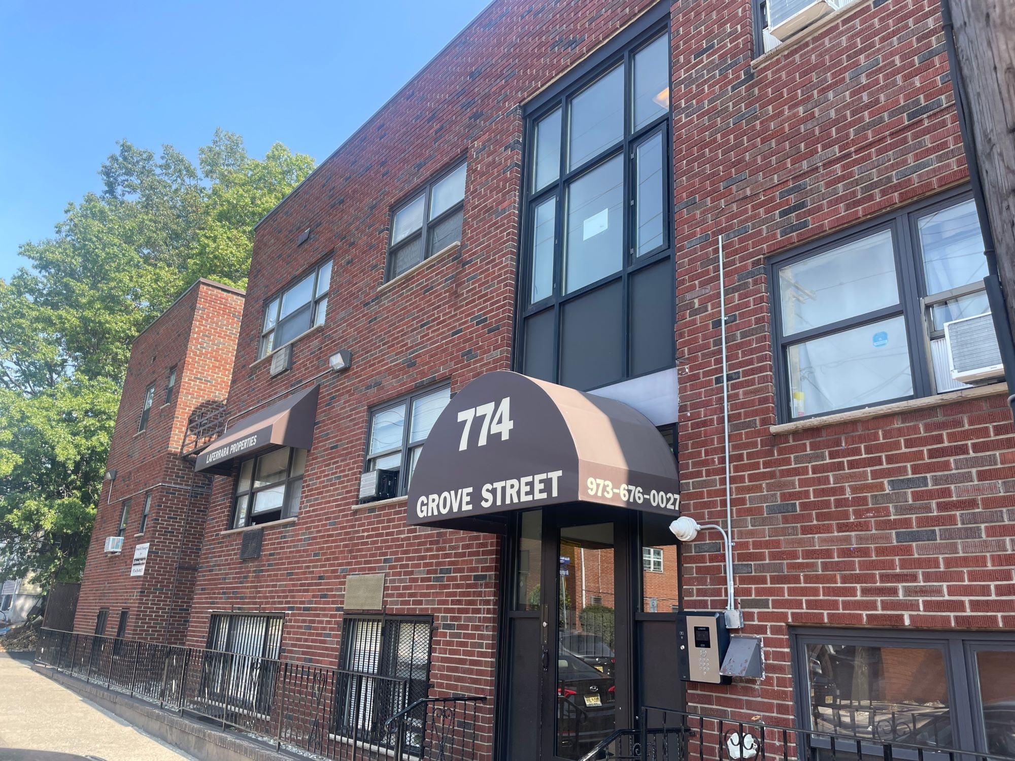 The building on Grove Street has a black awning and a brick facade.