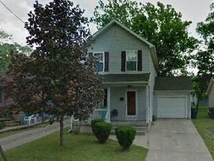 A two-story house with a red door and white trim.