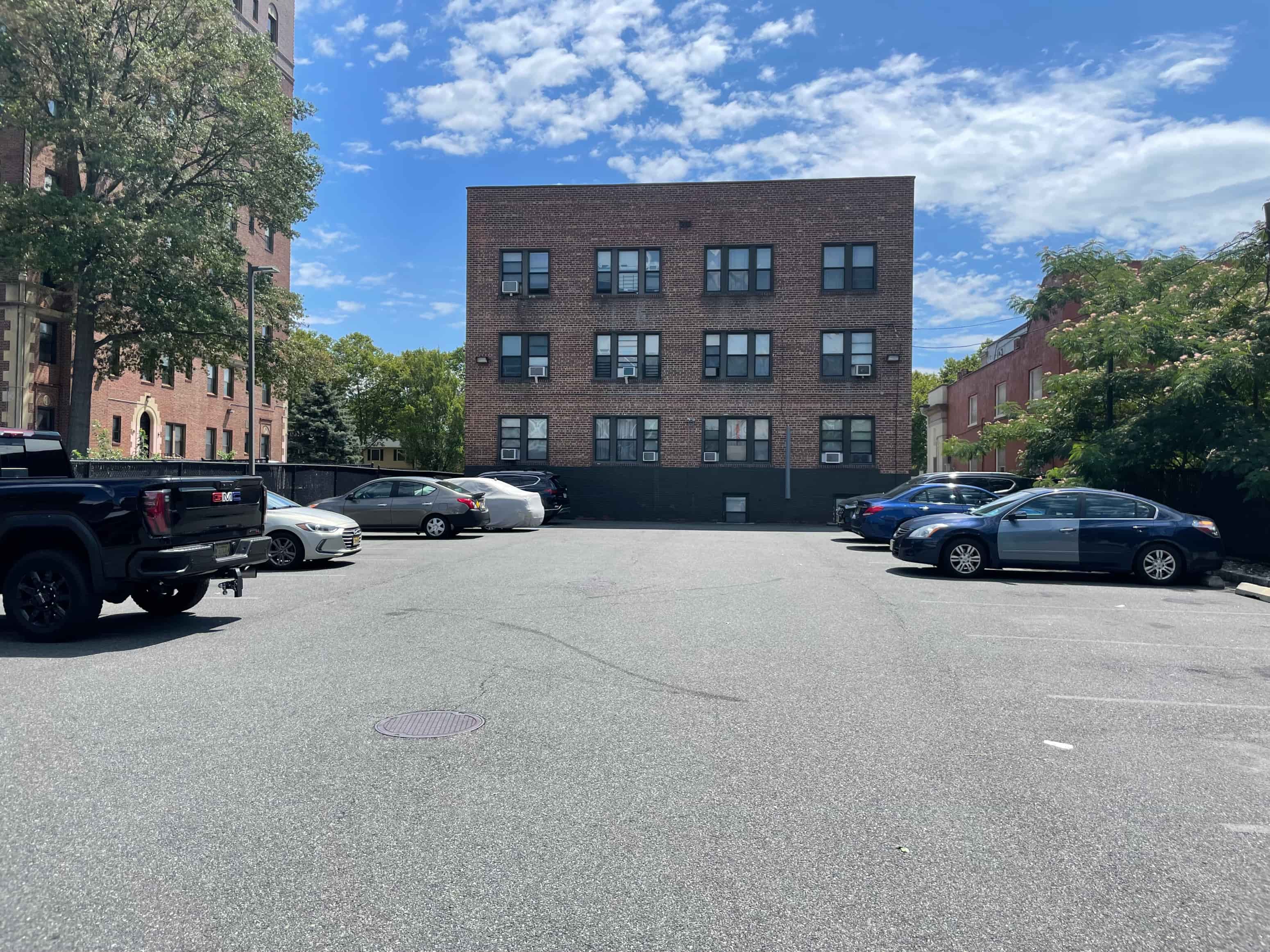 A parking lot with cars and a building in the background.