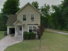 A house with a brown roof and a white garage door.